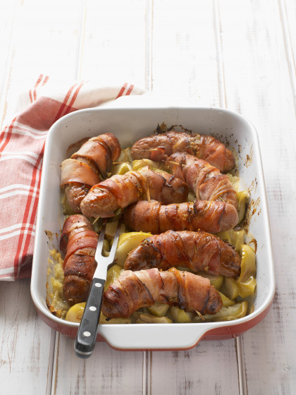 Bacon-wrapped sausages on apples
