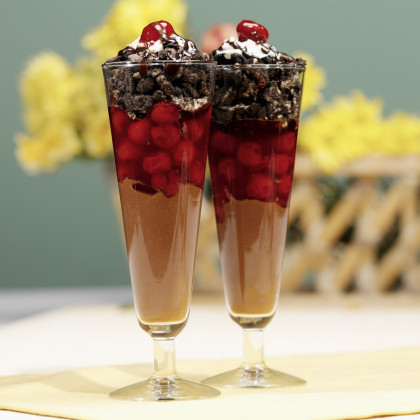 Layered dessert with chocolate pudding, cherries and chocolate cookies