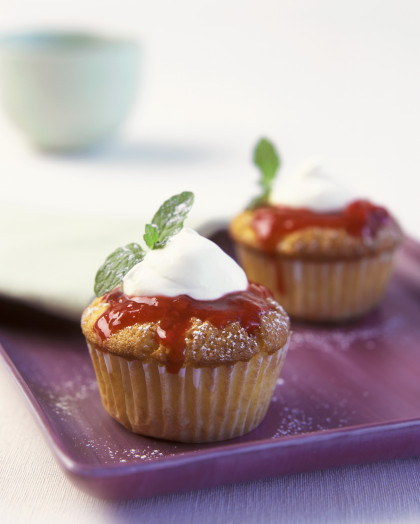 Berry muffins with cream topping and mint sprigs