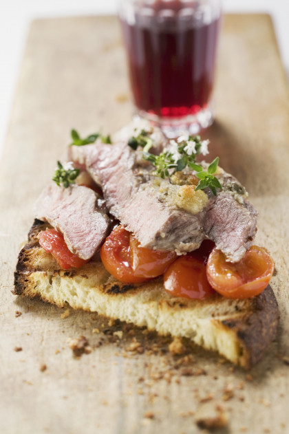 Steak with roast cherry tomatoes on grilled bread