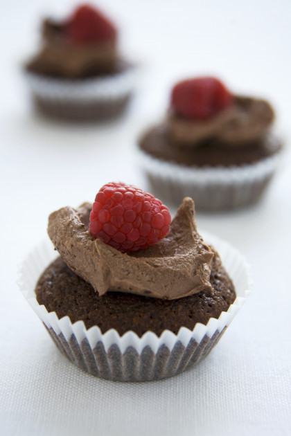 Gluten-free chocolate frosted cupcakes with raspberries
