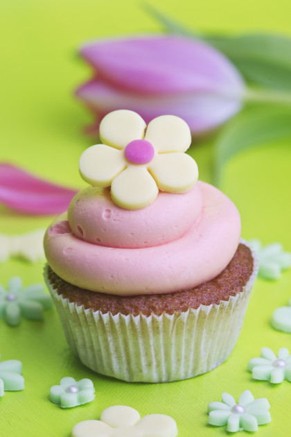 Cupcake with strawberry cream and a yellow sugar flower