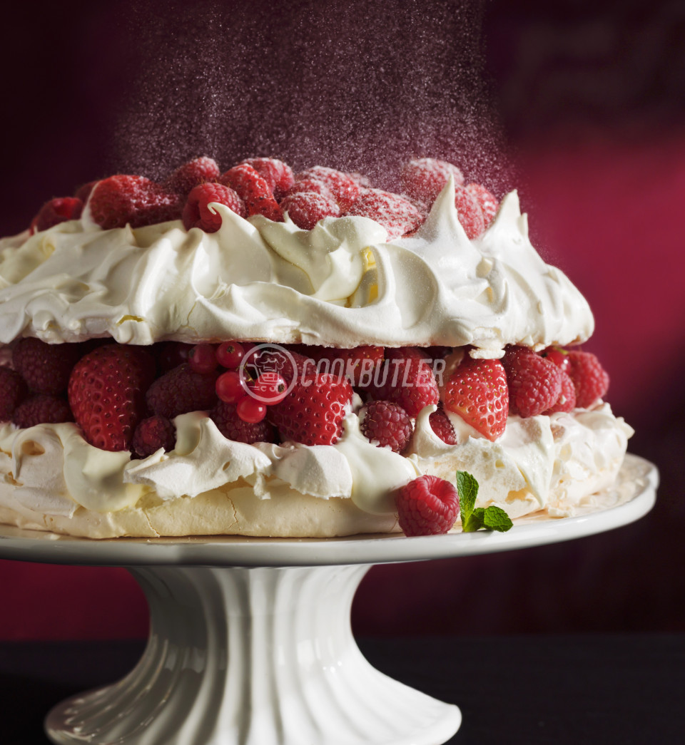 Berry Pavlova sprinkled with confectioner's sugar | preview