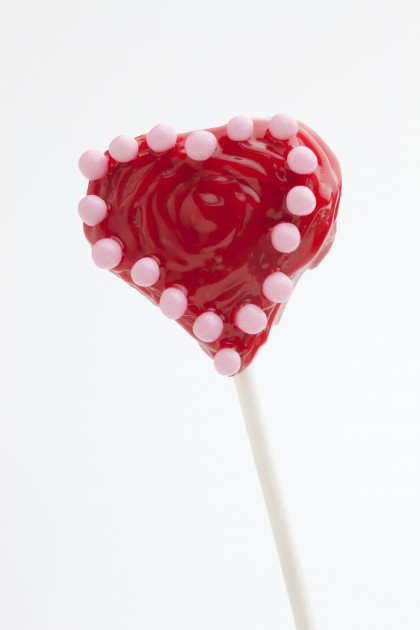 Red heart-shaped cake pop with pink sugar beads