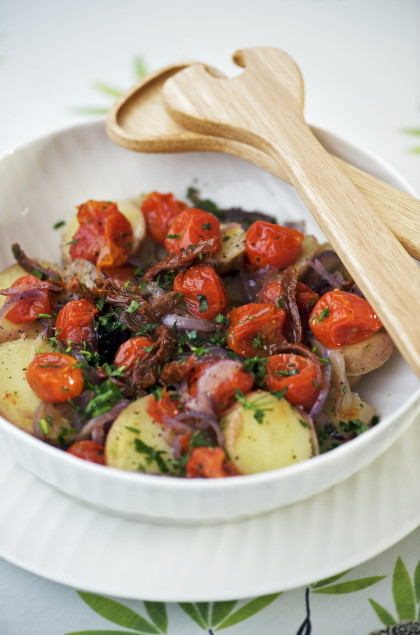 Warm potato salad with cherry tomatoes, onions and dried tomatoes