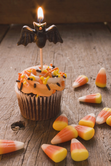Cupcake with bat candle and candy corn for Halloween (USA)