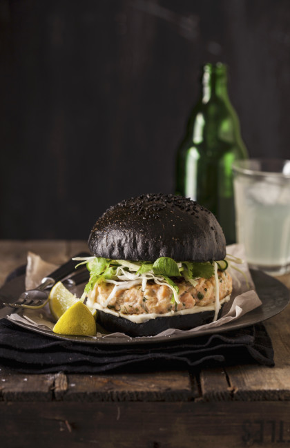 Salmon burger with a black brioche roll