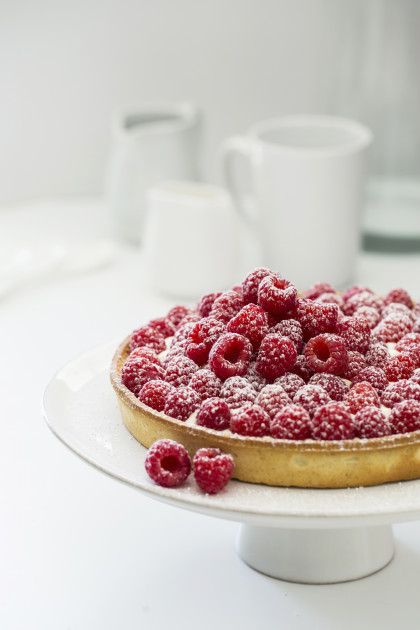 Raspberry tart with vanilla cream and icing sugar (gluten-free)