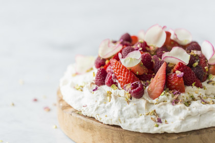 Rose and pistachio pavlova with fresh strawberries and raspberries, with pistachio nuts
