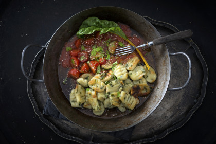Vegan pan-fried swiss chard gnocchi with tomato and courgette sauce