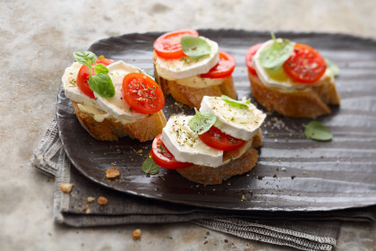 Canapés with goats cheese, cocktail tomatoes and oregano