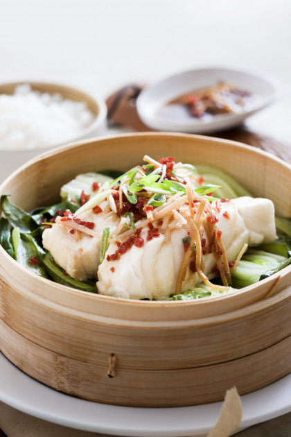 Steamed fish on a bed of bok choy with ginger and chilli
