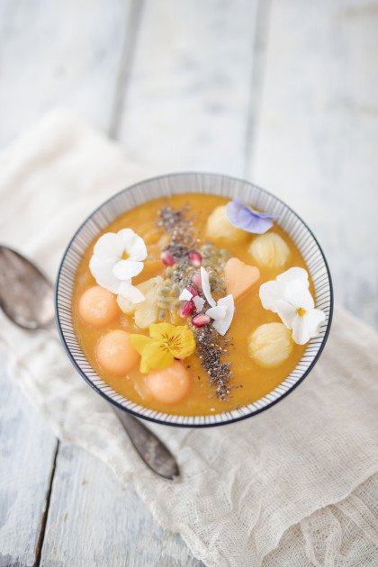 Smoothie bowl with cantaloupe melon, pineapple and coconut chips