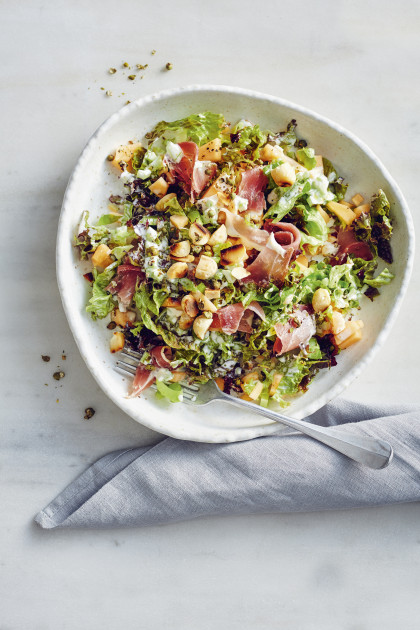 Colourful mixed leaf salad with melons, ham and macadamia nuts