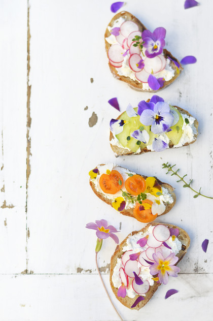 Sandwiches with cream cheese, vegetables and edible flowers